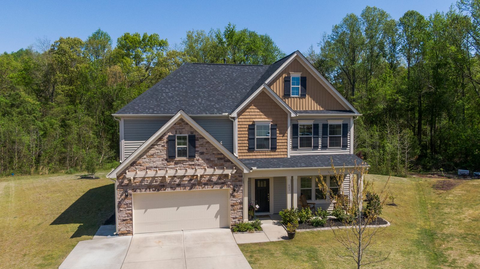 Modern suburban home with a clean dark shingle roof